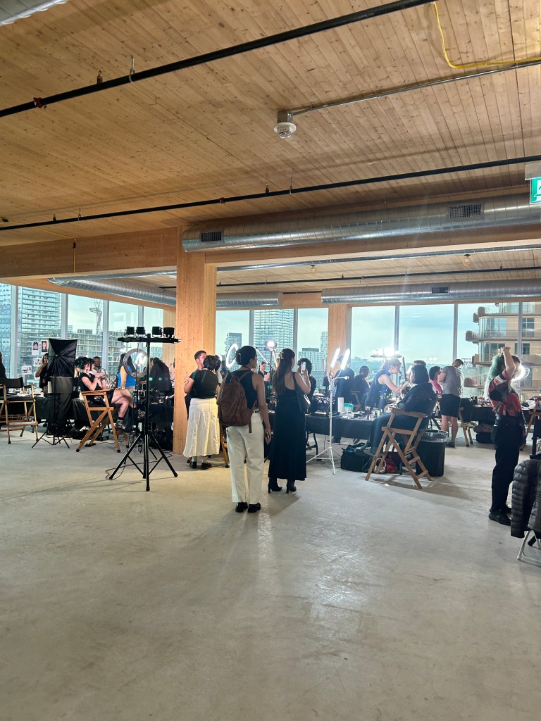 Backstage at Fashion Art Toronto's Spring/Summer 2025 season, featuring a bustling area with models, designers, and staff preparing for the show.